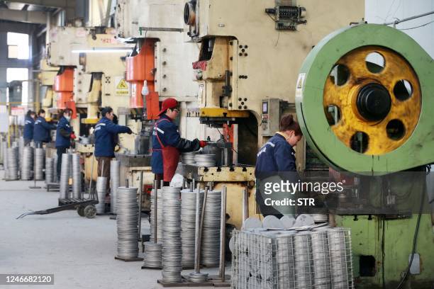 This photo taken on January 30, 2023 shows employees working on aluminum products at a factory in Huaibei, in China's eastern Anhui province. -...