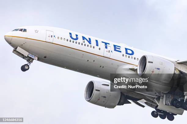 United Airlines Boeing wide body 777-200 aircraft as seen during take off and flying phase, passing in front of the air traffic control tower while...