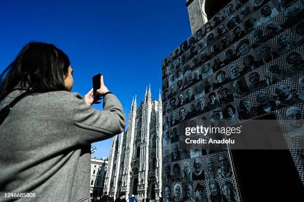 Woman takes a photo to the installation entitled âOra tocca a voiâ by participatory art project Inside Out by French artist JR in Milan, Italy on...