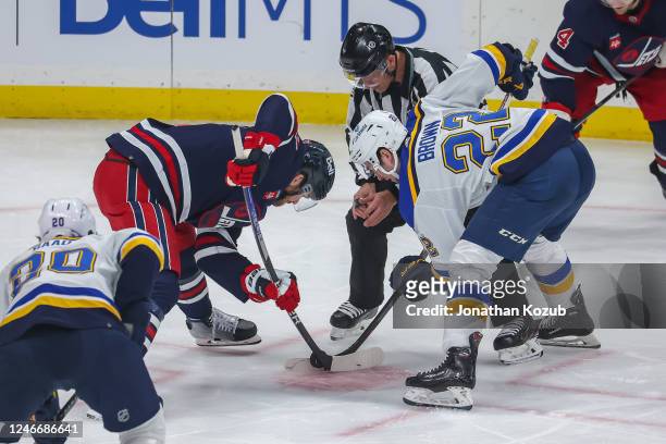 Adam Lowry of the Winnipeg Jets takes a second period face-off against Logan Brown of the St. Louis Blues at the Canada Life Centre on January 30,...