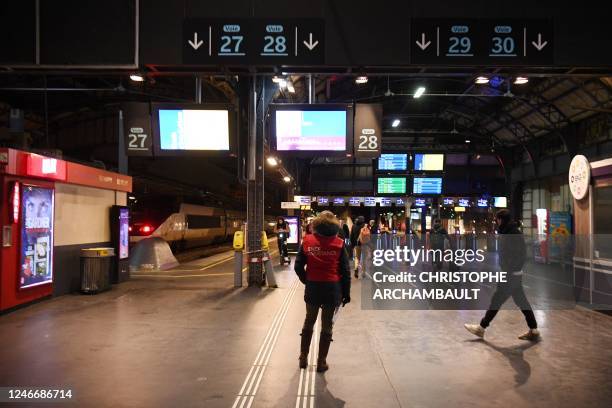 An assistant of French national railway company SNCF waits to inform travellers at Gare de l'Est train station on a second day of nationwide strikes...