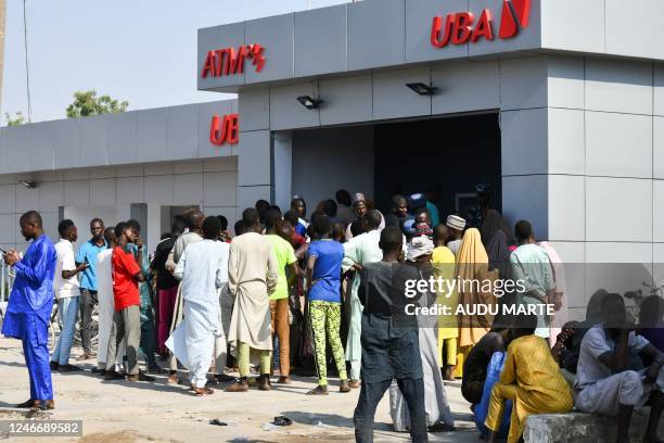 People queue to withdraw new Naira notes at an ATM in Maiduguri on January 29, 2023. - In October 2022 the Nigerian government announced without...