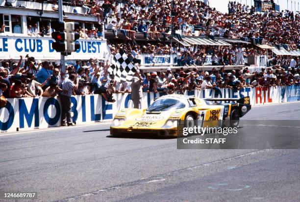 The Joest Racing team Porsche 956 N°7 of drivers German Klaus Ludwig and French Henri Pescarolo crosses the finish line on June 17, 1984 at the end...