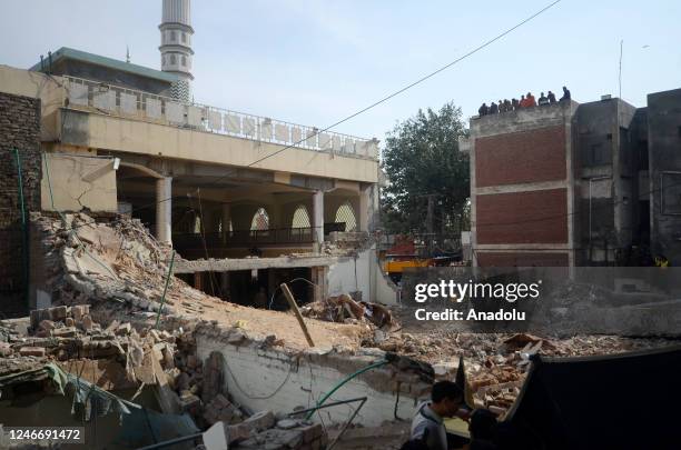 Rescue workers conduct search and rescue operation from the debris of damaged mosque a day after a blast inside the police headquarters in Peshawar...
