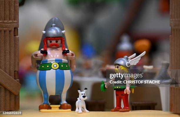 Characters from the French comic book series Obelix, Dogmatix and Asterix are seen at the booth of German toy company Playmobil during a preview of...