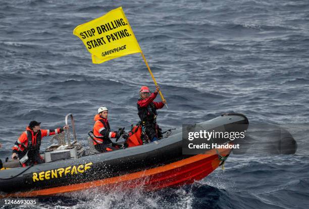 Greenpeace activist Yeb Saño from the Philippines holds aloft a flag on a rib after attempting to board a Shell oil platform being transported by the...