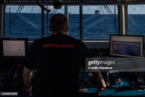 Captain of Greenpeace ship Arctic Sunrise looks out to the White Marlin ship transporting a Shell oil platform after being boarded by activists on...