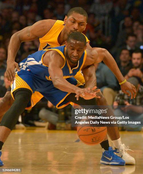 Golden State Warriors guard Ian Clark defends himself against Los Angeles Lakers forward Metta World Peace who fouled him on the play in the first...