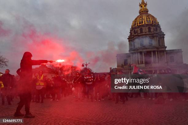 Protester holds a burning flare on the Place Vauban near the Hotel des Invalides during a rally on a second day of nationwide strikes and protests...