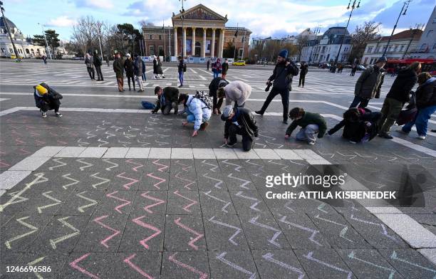 Teachers and students draw 16140 missing marks on the stone ground at the Heroes square in Budapest on January 31, 2023 to mark the end of a...