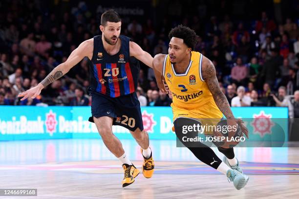 Maccabi Tel Aviv's US player Jalen Adams dribbles next to Barcelona's Argentinian guard Nicolas Laprovittola during the Euroleague basketball match...