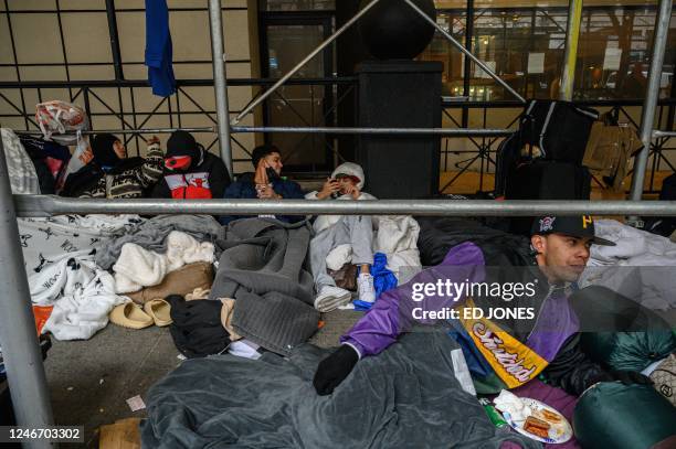 Migrants camp outside a hotel where they had previously been housed, as they resist efforts by the city to relocate them to a Brooklyn facility for...