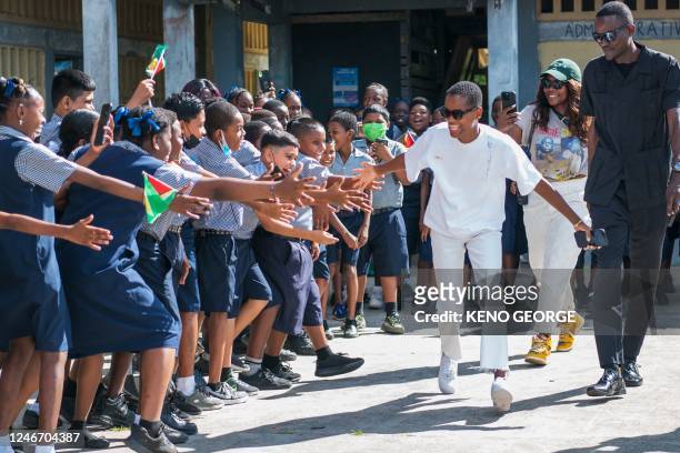 Guyanese actress Letitia Wright greets children during her arrival to the Patentia Primary School in Georgetown on January 31, 2023. - Letitia Wright...