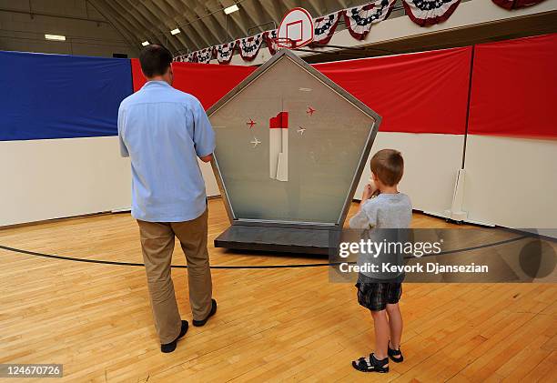 Jason Torrey Payne and his six years-old son Beck look at a sculpture " Towering Memories,'' that includes two shapes similar to the silhouette of...