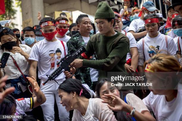 Protester performs with toy gun during a demonstration outside the Embassy of Myanmar in Bangkok on February 1 to mark the second anniversary of the...