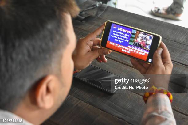 Man is seen watching on mobile the broadcast of Finance Minister Nirmala Sitharam announcing Union budget at Parliament , as seen in Kolkata , India...