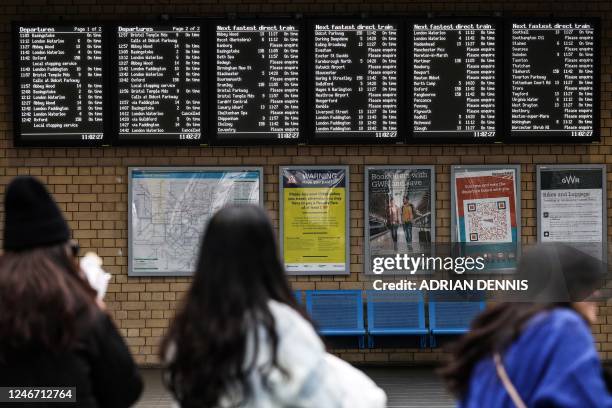 Commuters look at the departure board showing cancelled trains during a national strike, at the Reading train station, on February 1, 2023. -...