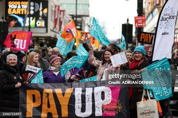 Teachers and members of the National Education Union hold placards during a demonstration called by the NEU trade unions in the streets of Reading,...