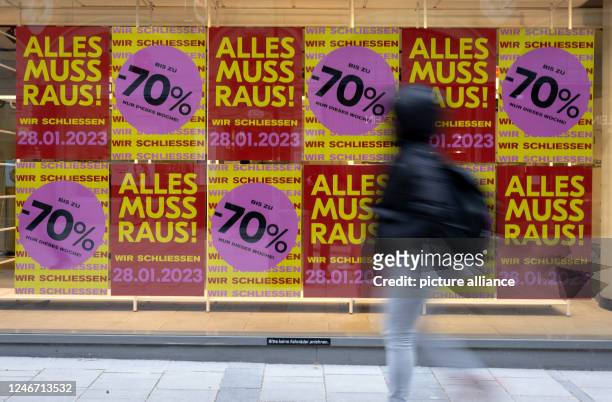 February 2023, Bavaria, Munich: Posters with the inscription "Alles muss Raus - Wir schließen" can be seen in the window of a store in the city...