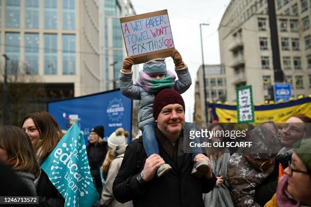 Child holds placard while taking part in a protest organised NEU and other affiliated trade unions in Saint Peter's square, in Manchester, on...