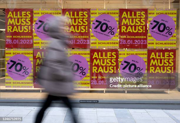 February 2023, Bavaria, Munich: Posters with the inscription "Alles muss Raus - Wir schließen" can be seen in the window of a store in the city...