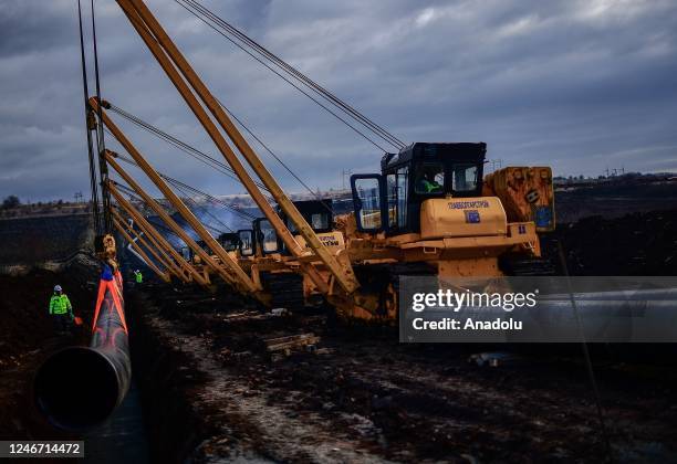 Worker walks past heavy machinery during the opening of the specialized construction activities for the construction of the intersystem gas...