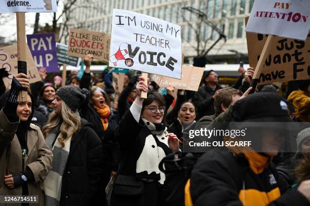 Teacher hold a placard as they shout slogans while taking part in a protest organised NEU and other affiliated trade unions in Saint Peter's square,...