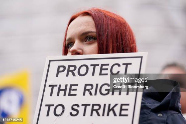 Striking worker holds a placard which reads "Protect The Right To Strike" during joint strike action by train drivers, teachers, university staff and...