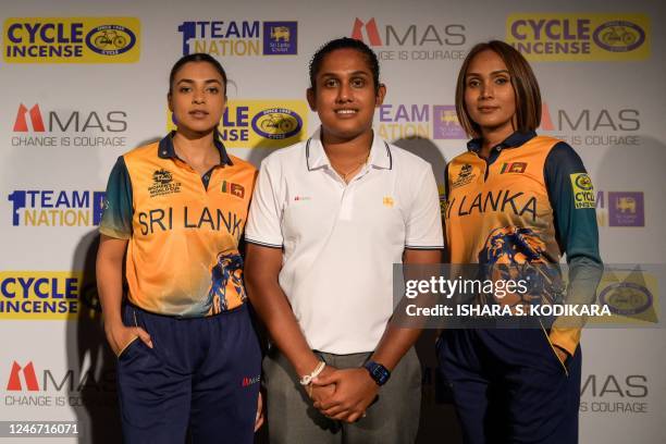 Sri Lanka's women's cricket team captain Chamari Athapaththu poses next to models wearing Sri Lanka's cricket team new jersey ahead of the upcoming...
