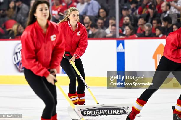 Calgary Flames ice girls shovel snow during the third period of an NHL game between the Calgary Flames and the Chicago Blackhawks on January 26 at...