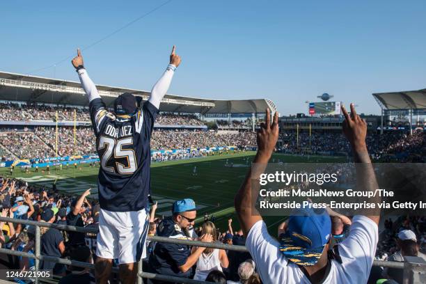 Chargers fan Jonathan Rodriguez, left, celebrates the team's touchdown during an exhibition game against the Seahawks at StubHub Center in Carson on...