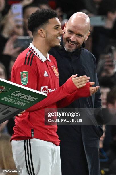 Manchester United's Dutch manager Erik ten Hag talks with Manchester United's English striker Jadon Sancho as Sancho waits to be substituted on...