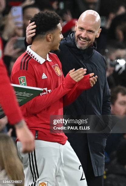 Manchester United's Dutch manager Erik ten Hag talks with Manchester United's English striker Jadon Sancho as Sancho waits to be substituted on...