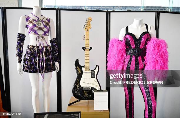Harry Styles signed and inscribed Fender Statocaster electric guitar, an Olivia Rodrigo signed 2022 Glastonbury Festival stage-worn outfit and a Katy...