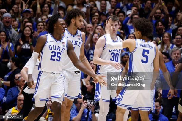 Mark Mitchell, Dereck Lively II, Kyle Filipowski and Tyrese Proctor of the Duke Blue Devils react following a play against the Wake Forest Demon...