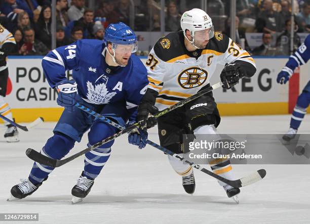 Patrice Bergeron of the Boston Bruins battles against Morgan Rielly of the Toronto Maple Leafs during an NHL game at Scotiabank Arena on February 1,...