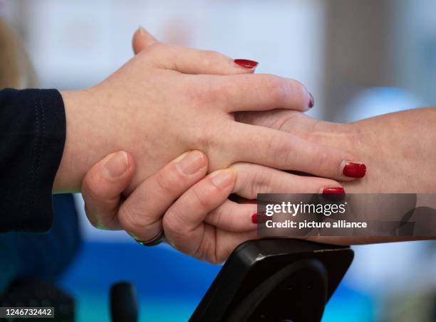 January 2023, Hesse, Wiesbaden: In the living area of the "Bärenherz" children's hospice, Jeanette Ott holds the hand of her daughter Catherine. The...