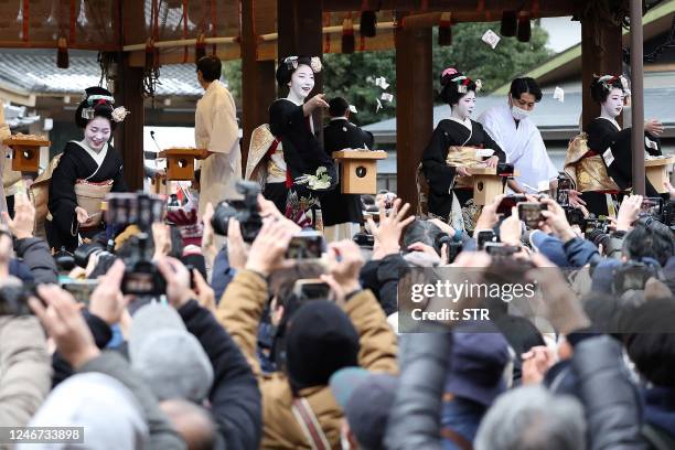 Traditional "maikos" , or apprentice "geishas", in traditional dress distribute small packets of beans to drive away evil spirits and welcome in the...