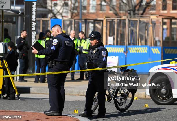 Police officers stand near shell casings the are marked with numbers at shooting that had one fatality at the Potomac Avenue Metro station at 14th...