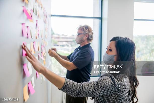 business leaders brainstorming with notes - brainstorming stock pictures, royalty-free photos & images