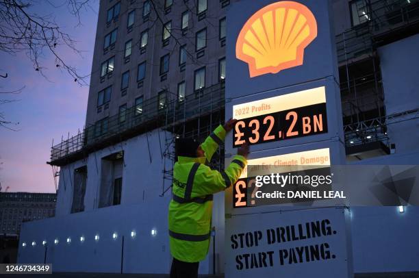 Activists from Greenpeace set up a mock-petrol station price board displaying the Shell's net profit for 2022, as they demonstrate outside the...