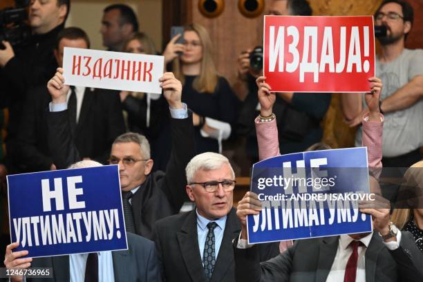 Group of MPs hold banners reading "No to the ultimatum" and "Treason" as Serbian President informs MPs about the latest negotiating process with...