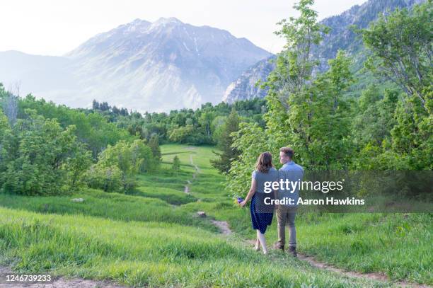 young couple walking along a mountain meadow trail near buffalo peak in the wasatch range - mt timpanogos stock pictures, royalty-free photos & images