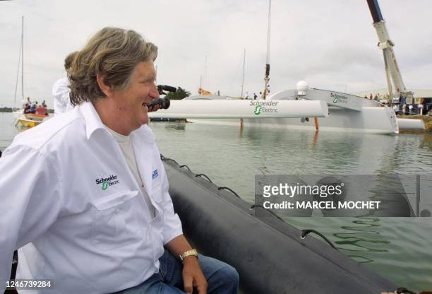 Le navigateur Olivier de Kersauson passe, le 22 Juillet 2001 dans le port de Vannes, près de son nouveau multicoque lors de sa mise à l'eau. Long de...