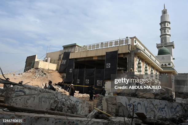 Members of the media gather beside the damaged mosque following January's 30 suicide blast inside the police headquarters in Peshawar on February 2,...