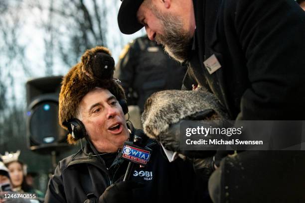 Groundhog handler AJ Dereume holds Punxsutawney Phil for an interview with WTAJ reporter, who saw his shadow, predicting a late spring during the...