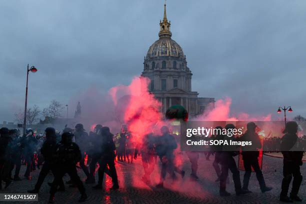 Demonstrators clash with police amid clouds of smoke and fire flares during a demonstration in Paris. A French pension reform strike took place for...