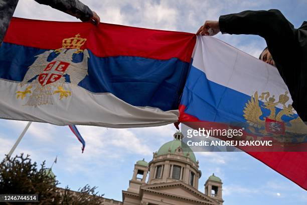 People hold flags of Serbia and Russia as they protest outside the National Assembly building in Belgrade on February 2 during a special parliament...