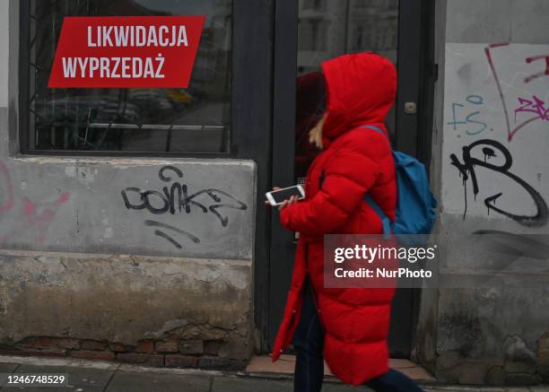 Woman walks past a business premises with the sign 'liquidation, sale' in a window, in the center of Krakow, Poland on February 02, 2023. In 2022,...