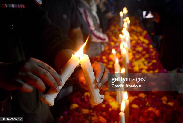 Policemen light candles to pay tribute to the victims of the mosque suicide blast inside a police headquarters in Peshawar, during a vigil in Quetta,...